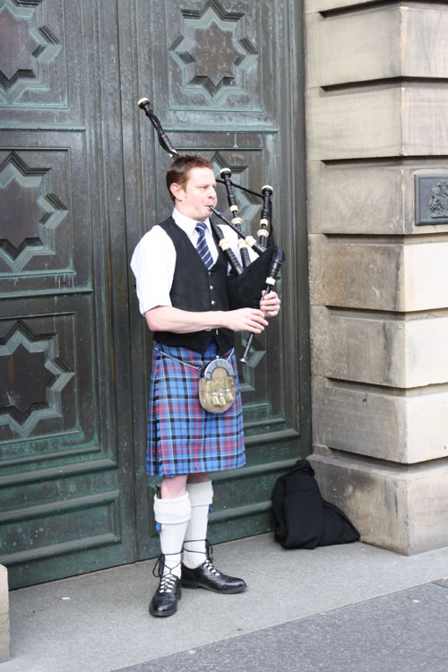 ... man wearing a kilt and playing backpipe